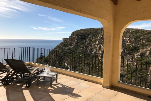Sun loungers and a bottle of cava on the terrace, looking out to the sea and mountain
