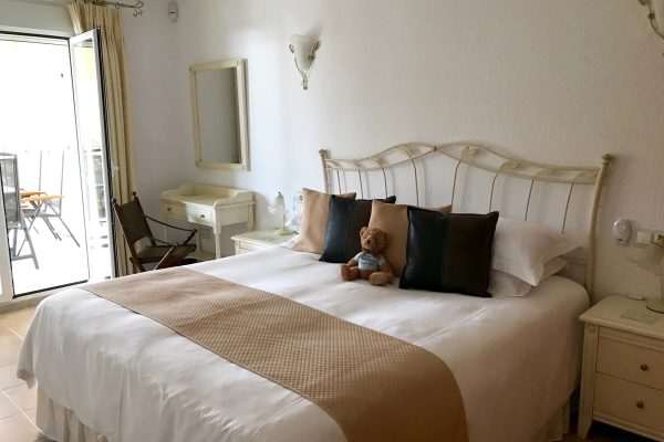 Super-king size bed in the Casa Windlenook master bedroom, with cushions, runner and teddy on the bed